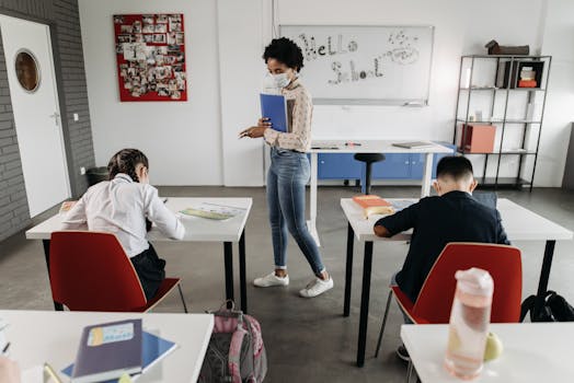 Teacher instructing masked students in a classroom setting, adapting to pandemic norms.