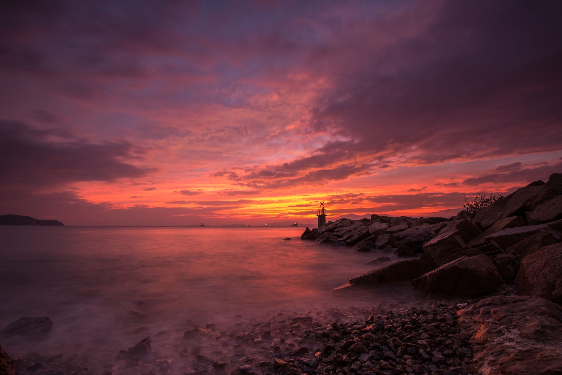 Breathtaking sunset over rocks and water on Hong Kong Island with colorful skies.