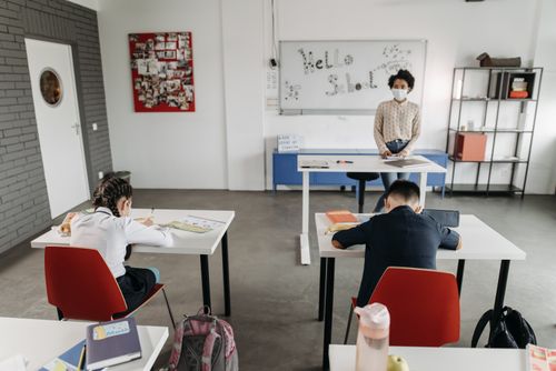 Free A classroom scene with children and a teacher wearing masks, a sign of new normal education. Stock Photo