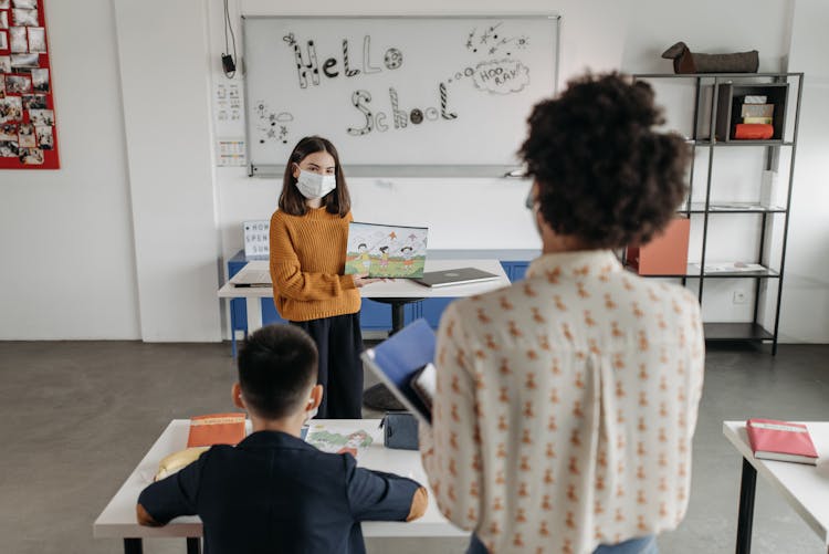 A Young Girl Explaining To Her Teacher