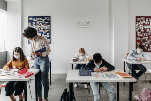 Students and teacher in masks in a classroom setting post-pandemic, focusing on safe learning.