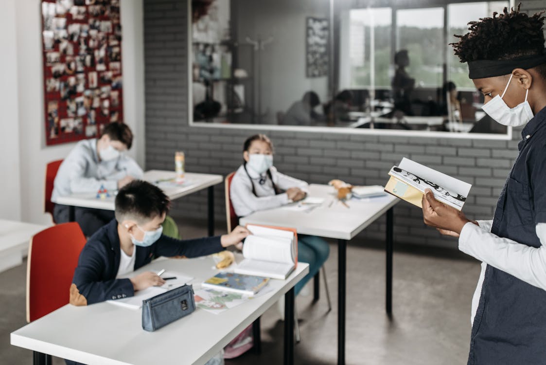 Free A Teacher Reading a Book in Front of the Class Stock Photo