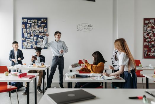 Students interact playfully in a modern classroom setting, showcasing diversity and camaraderie.