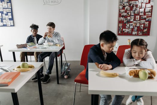 Diverse group of children eating lunch in a modern classroom setting.