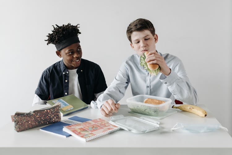 A Boy Eating A Sandwich From A Lunchbox