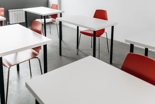 Free Close-Up Photo of Desks and Chairs Inside the Classroom Stock Photo