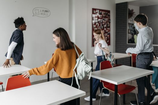 A group of cheerful students leaving a classroom, indicating a positive school environment. 8423446