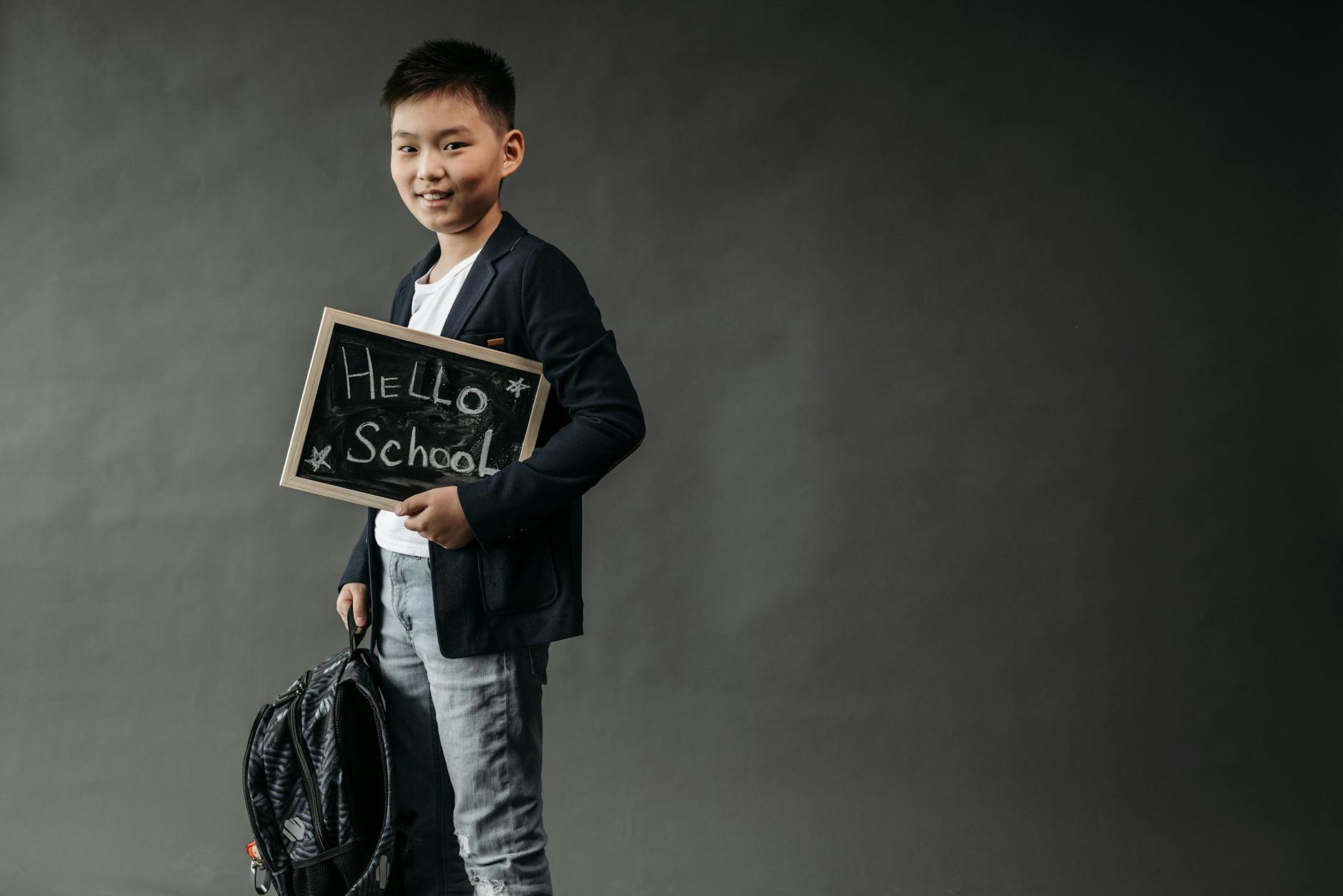 Avusturya'daki okul masraflarını ve eğitim giderlerini temsil eden, Euro madeni paralar ile birlikte okul araç gereçleri ve sırt çantalı bir öğrenci.