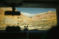 透过汽车挡风玻璃，可以看到充满活力的沙漠景观和色彩缤纷的岩石结构