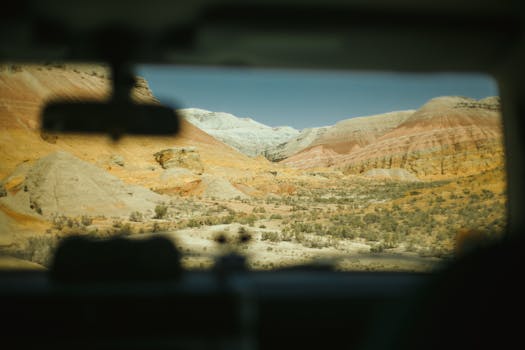 透过汽车挡风玻璃，可以看到充满活力的沙漠景观和色彩缤纷的岩石结构