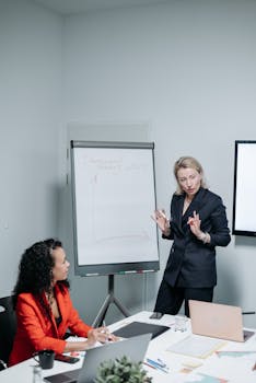 Two professional women discussing a business strategy in an office.
