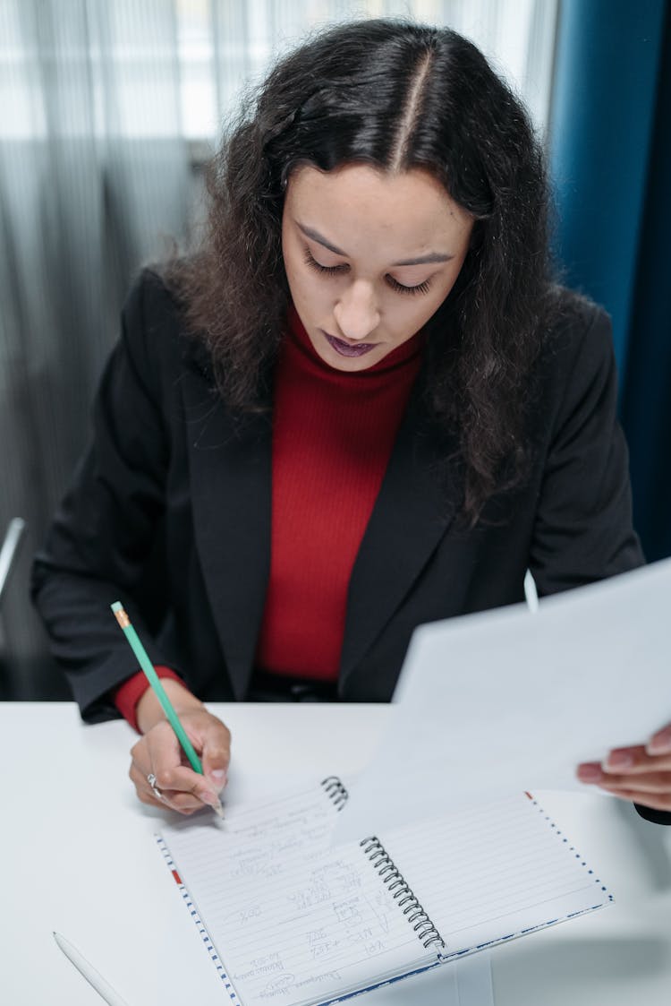 Woman In Black Blazer Writing On Notebook