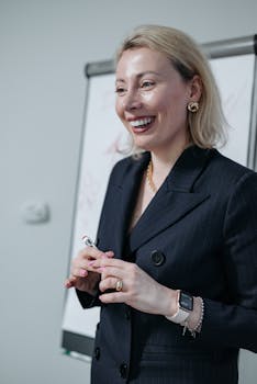 Smiling businesswoman in a suit presenting at a meeting, conveying leadership and confidence.