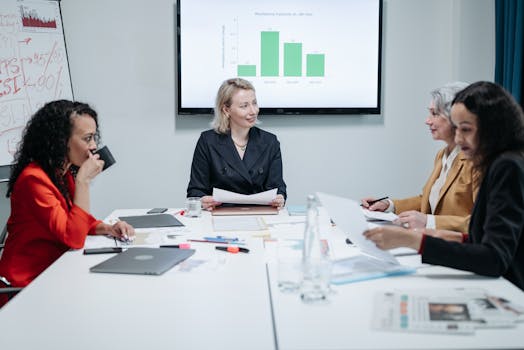 Businesswomen engaged in a productive meeting in a modern conference room with charts displayed.
