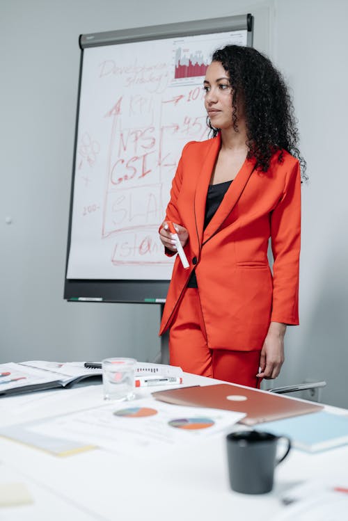 Woman in Red Blazer Standing Inside the Office
