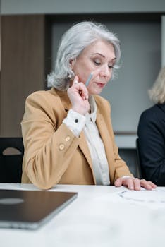 Senior woman in business attire planning and brainstorming in a modern office setting.