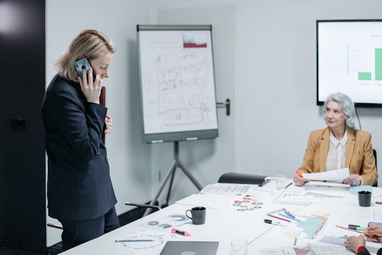 Business Woman Having A Phone Call While In A Meeting