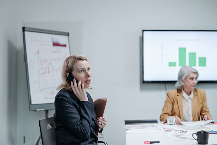 Business Woman Having A Phone Call While In A Meeting