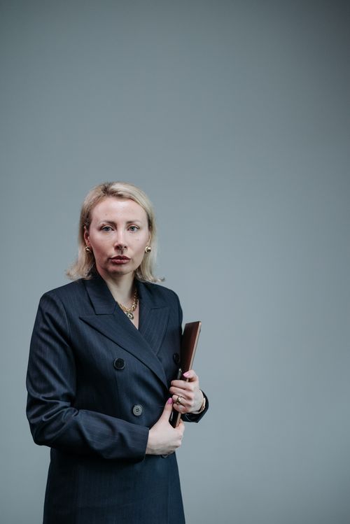 Free Professional woman in navy blazer holding tablet against gray background. Stock Photo