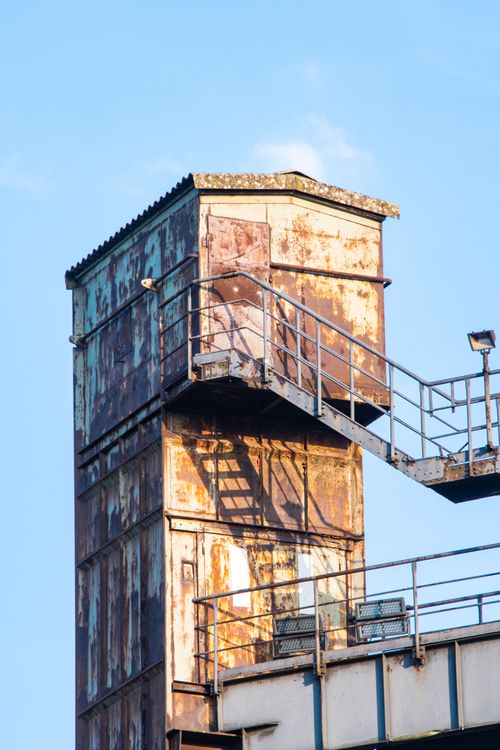 Free Rusted industrial building with stairs under a blue sky in Duisburg, Germany. Stock Photo
