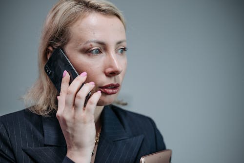 Black woman talking on smartphone and browsing laptop for work · Free ...