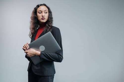 Woman in Business Attire Carrying a Laptop