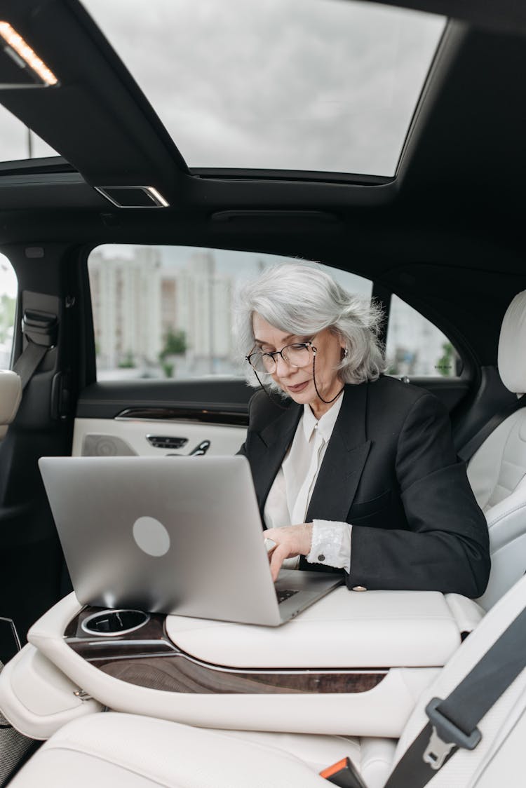 An Elderly Woman Working Inside A Car