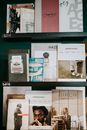 A bookshelf displaying an assortment of modern magazines and books in a stylish indoor setting.