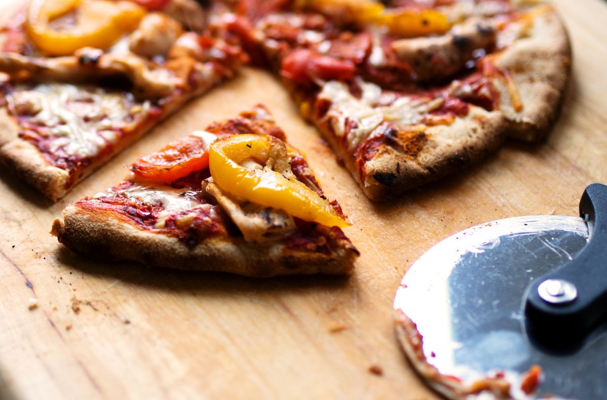 Pizza cargada con jamón, tocino y champiñones