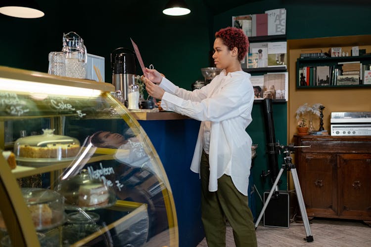 A Woman Holding A Menu In A Café