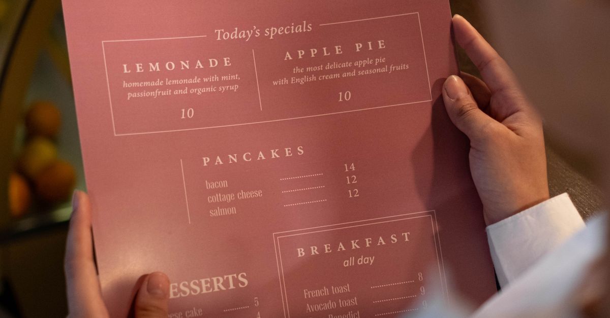 A person holding a menu from Rosie's Coffee showing various food and beverage options.