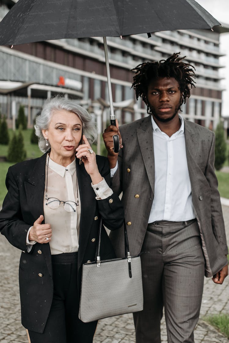 Man Holding Umbrella Beside A Woman