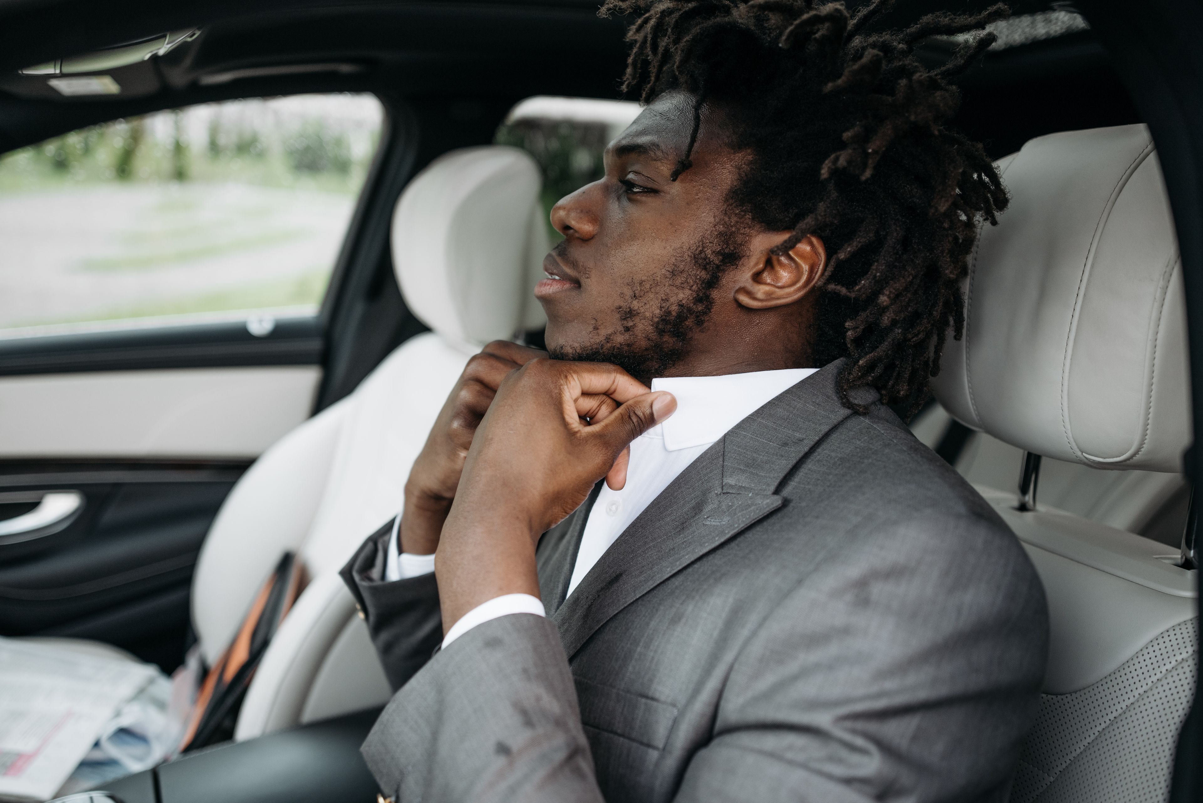 A professional chauffeur waiting beside a luxury car