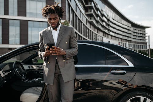 Man in Gray Suit Standing Beside Black Car