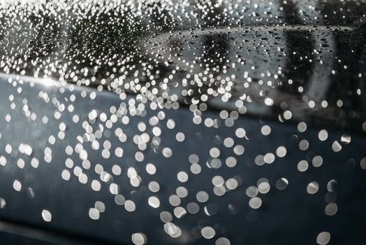 Macro shot showcasing water droplets on a shiny surface with bokeh effect.
