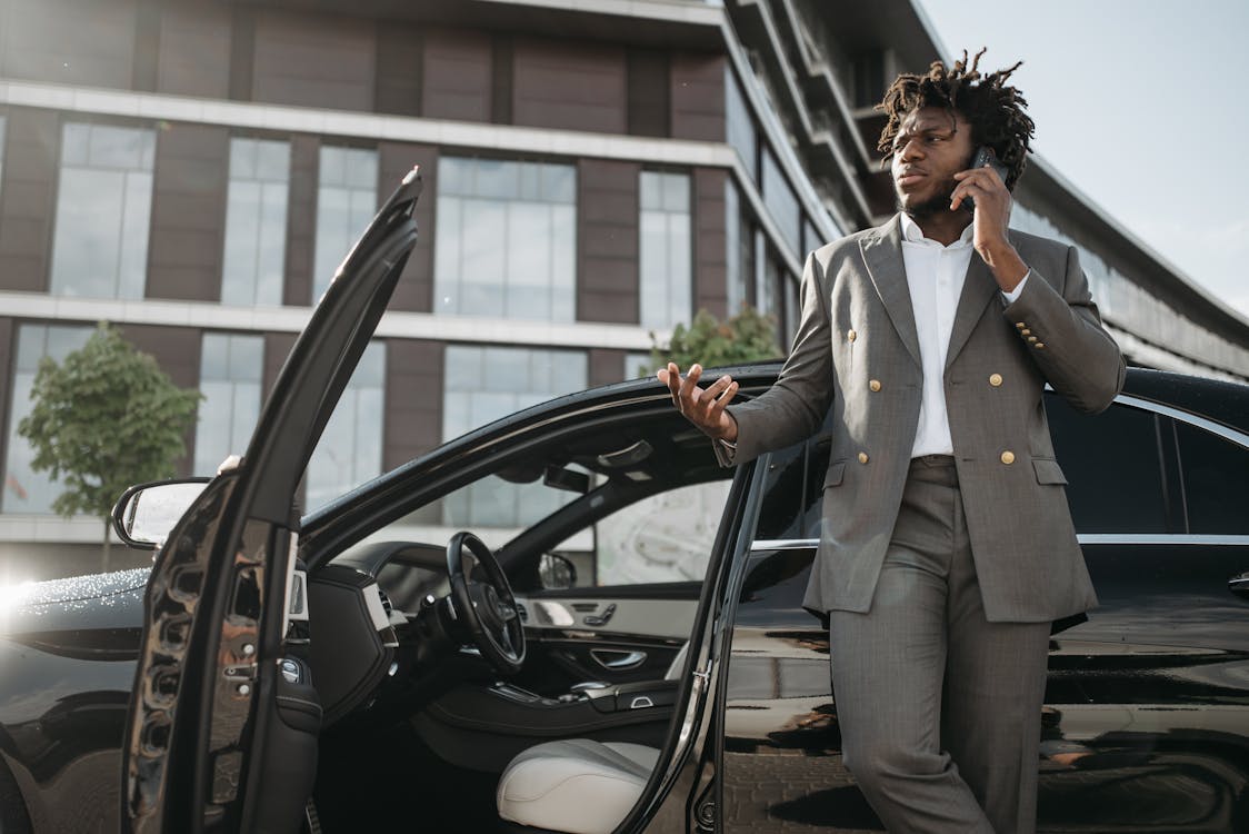 Man in Gray Suit Standing Beside Black Car While Having a Phone Call ...