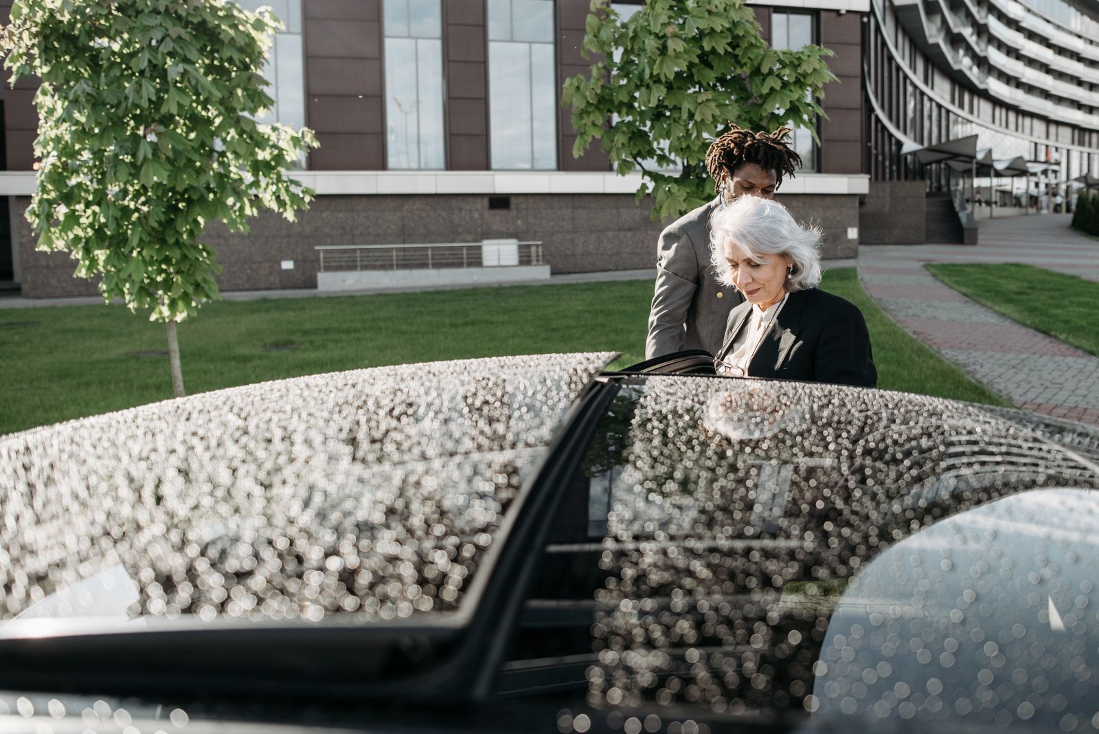 Senior woman being assisted while entering a vehicle