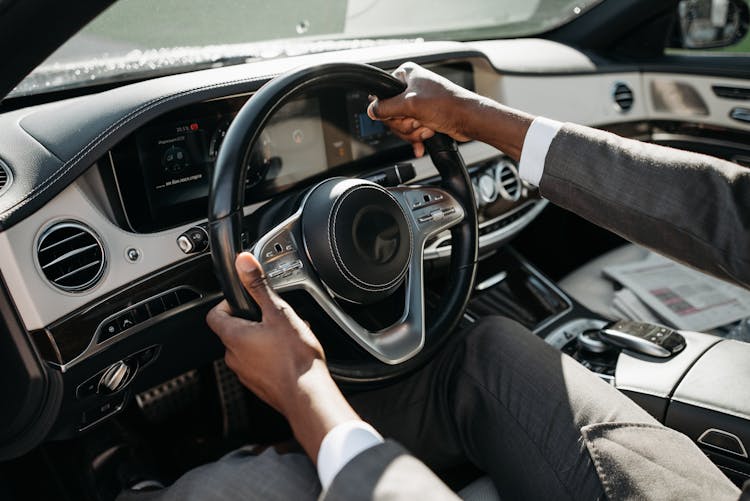 A Person In Gray Suit Driving A Car