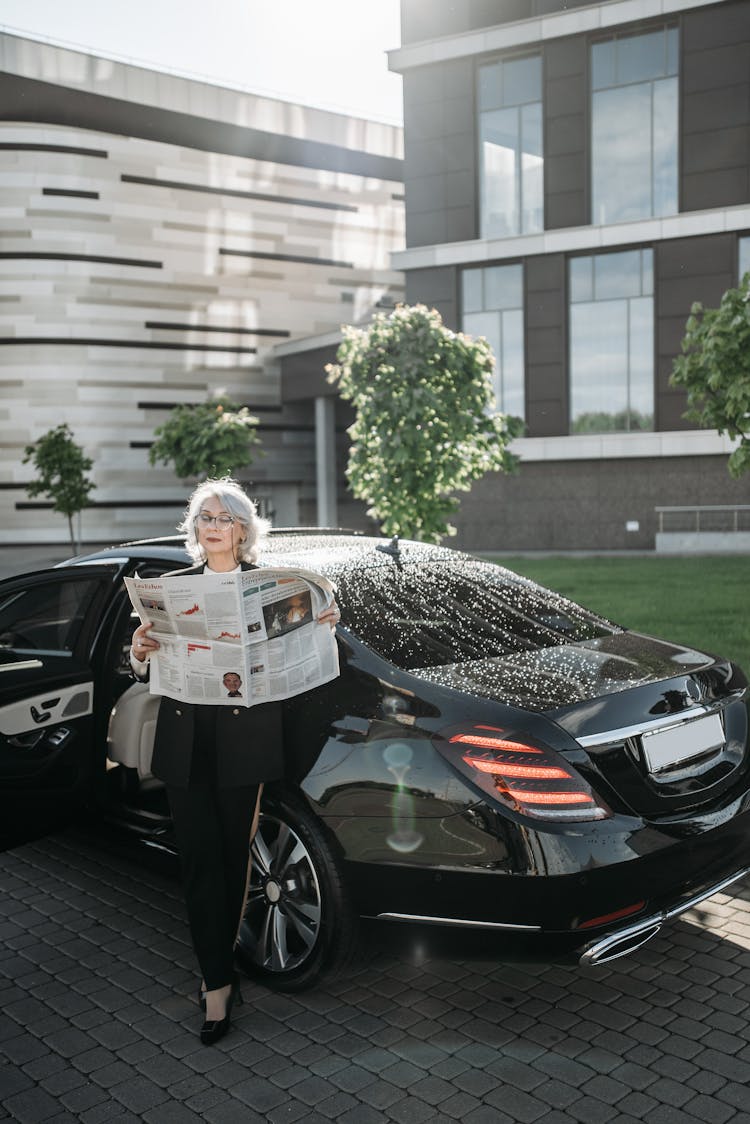 Woman In Black Suit Reading A Newspaper