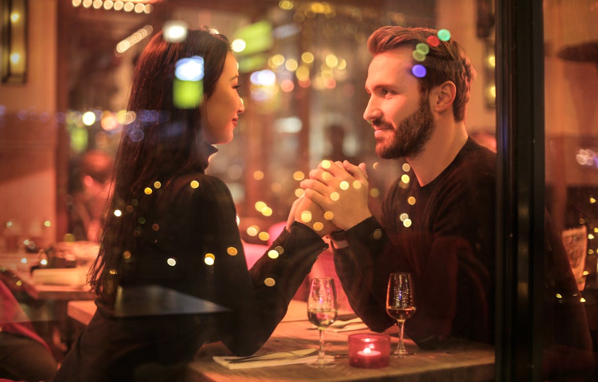 A couple holding hands and looking at each other.