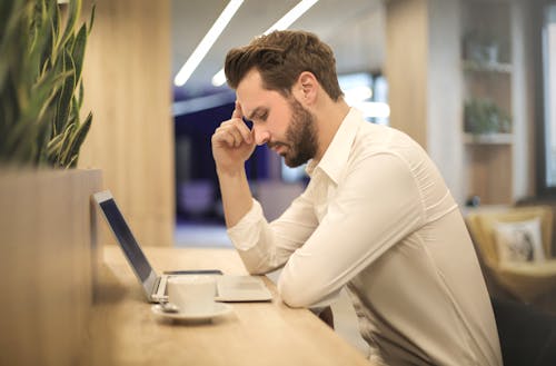 Man Met Hand Op Tempel Laptop Kijken