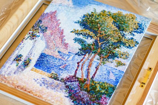 A close-up of an impressionist landscape painting depicting a serene lakeside scene on canvas.