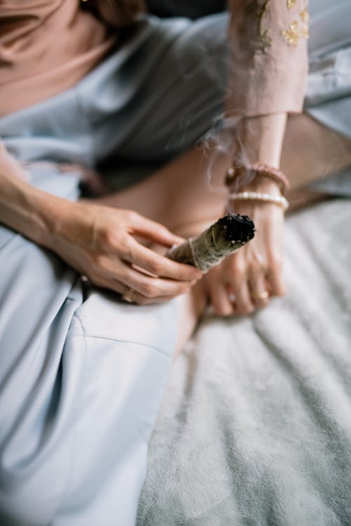 Person Holding a Burning Sage