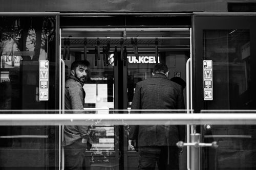 Free Black and white photo of two men boarding a subway train, urban transport scene. Stock Photo
