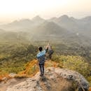 在印度尼西亚加里曼丹中部，一名男子正指着风景优美的曼道塔拉旺山脉