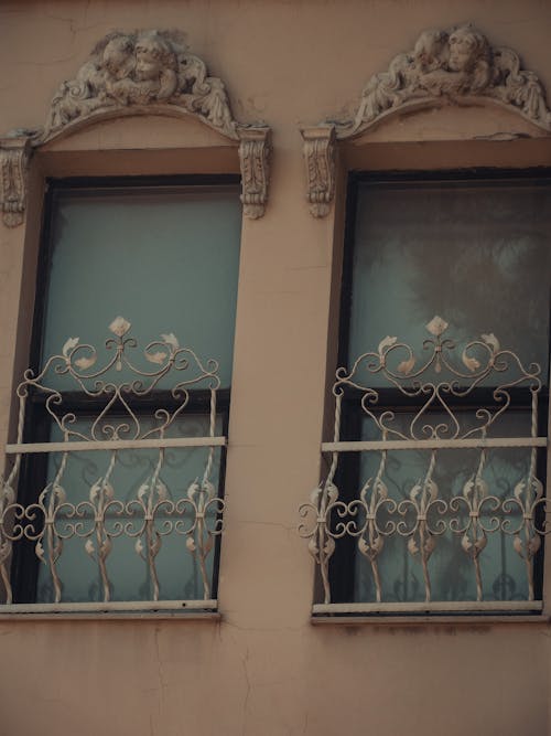 Low angle of aged residential building with forged metal fence and stucco ornament