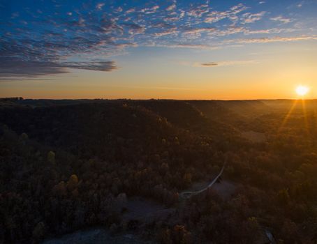 A stunning aerial view of a sunset over a forest landscape in Beaver, MN, showcasing fall colors and dramatic skies.
