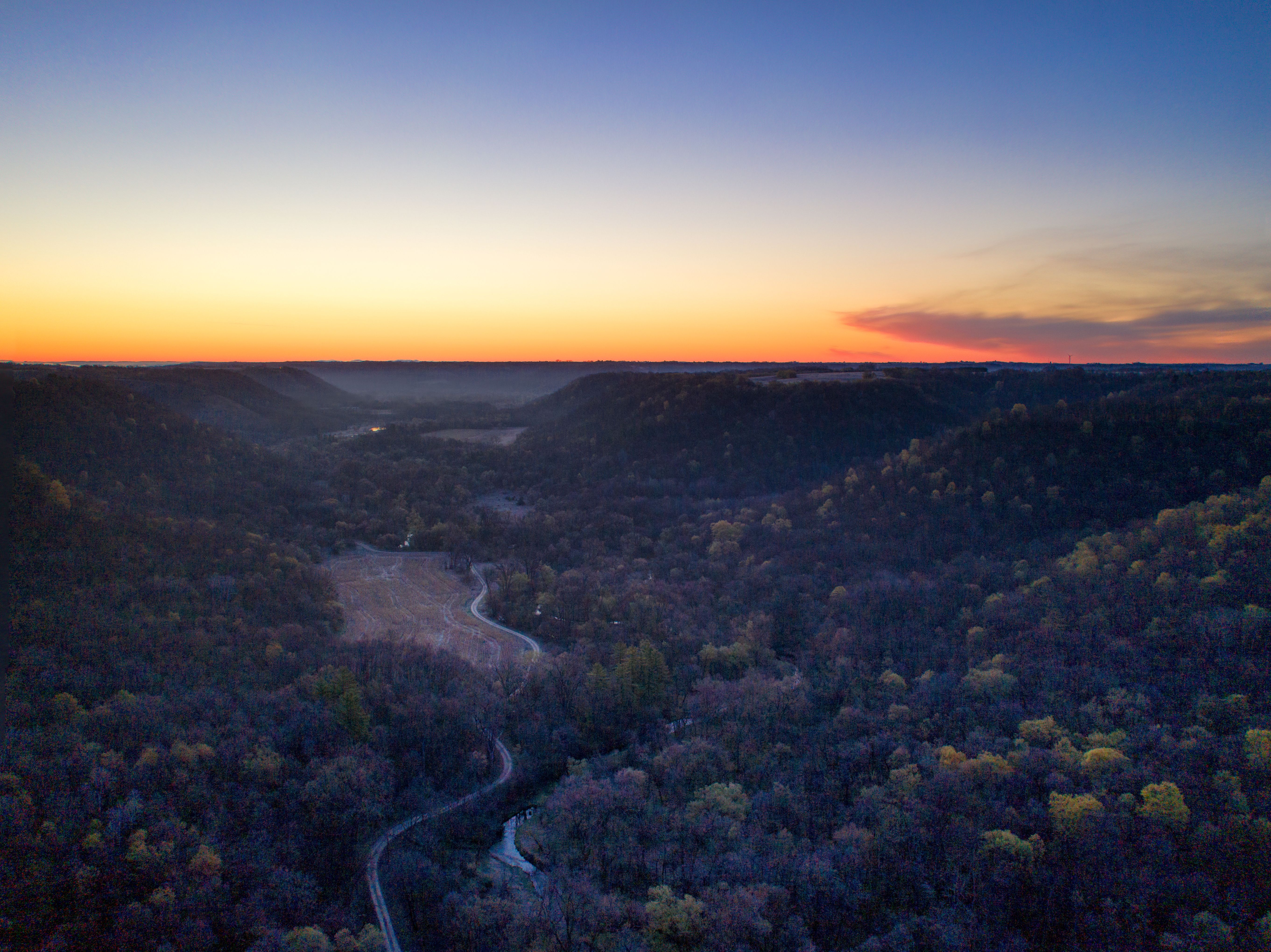 A stunning aerial view of a winding road and forest in Beaver, MN during dawn.