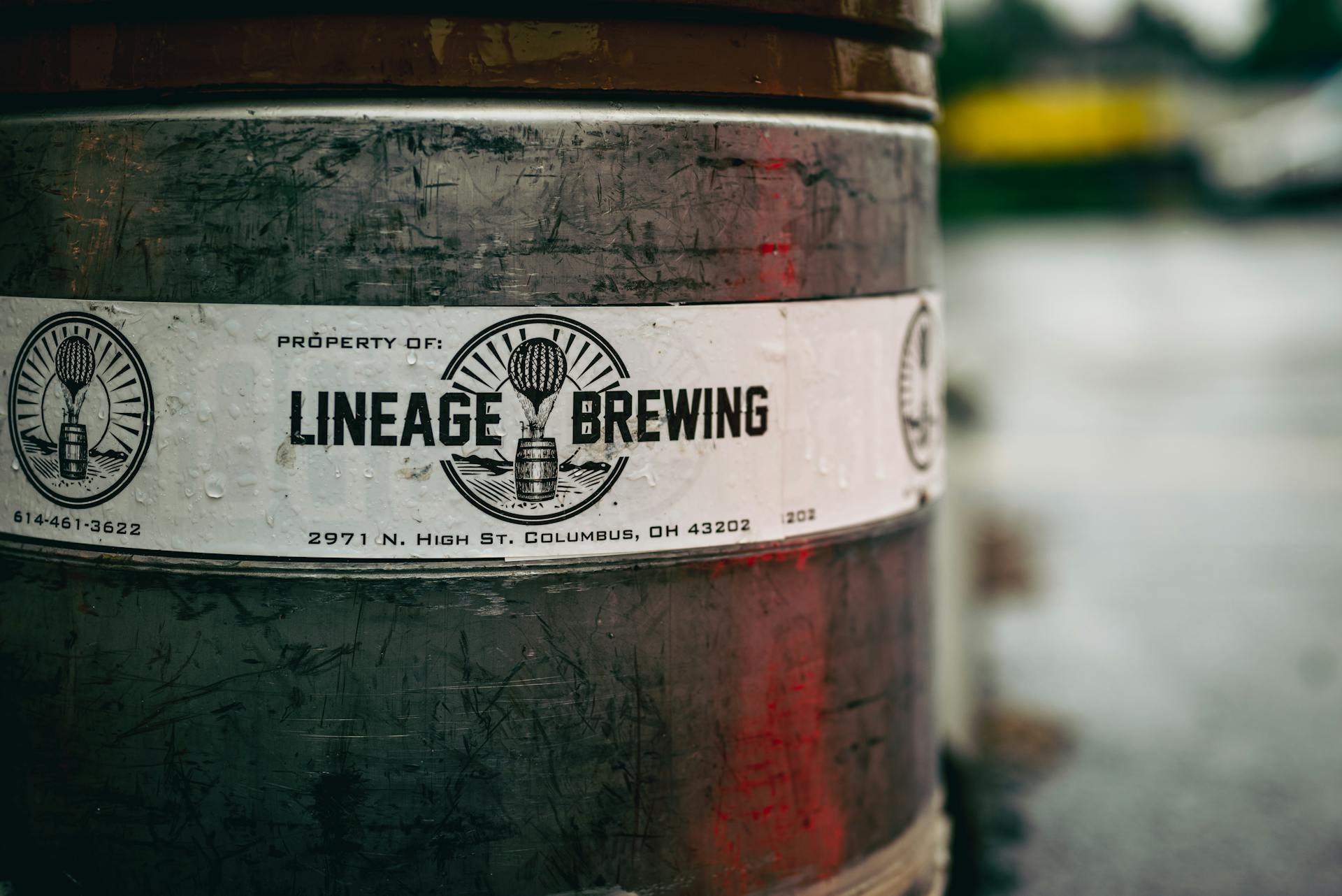 Close-up photo of a Lineage Brewing barrel with label details. Captured outdoors, offers an industrial feel.