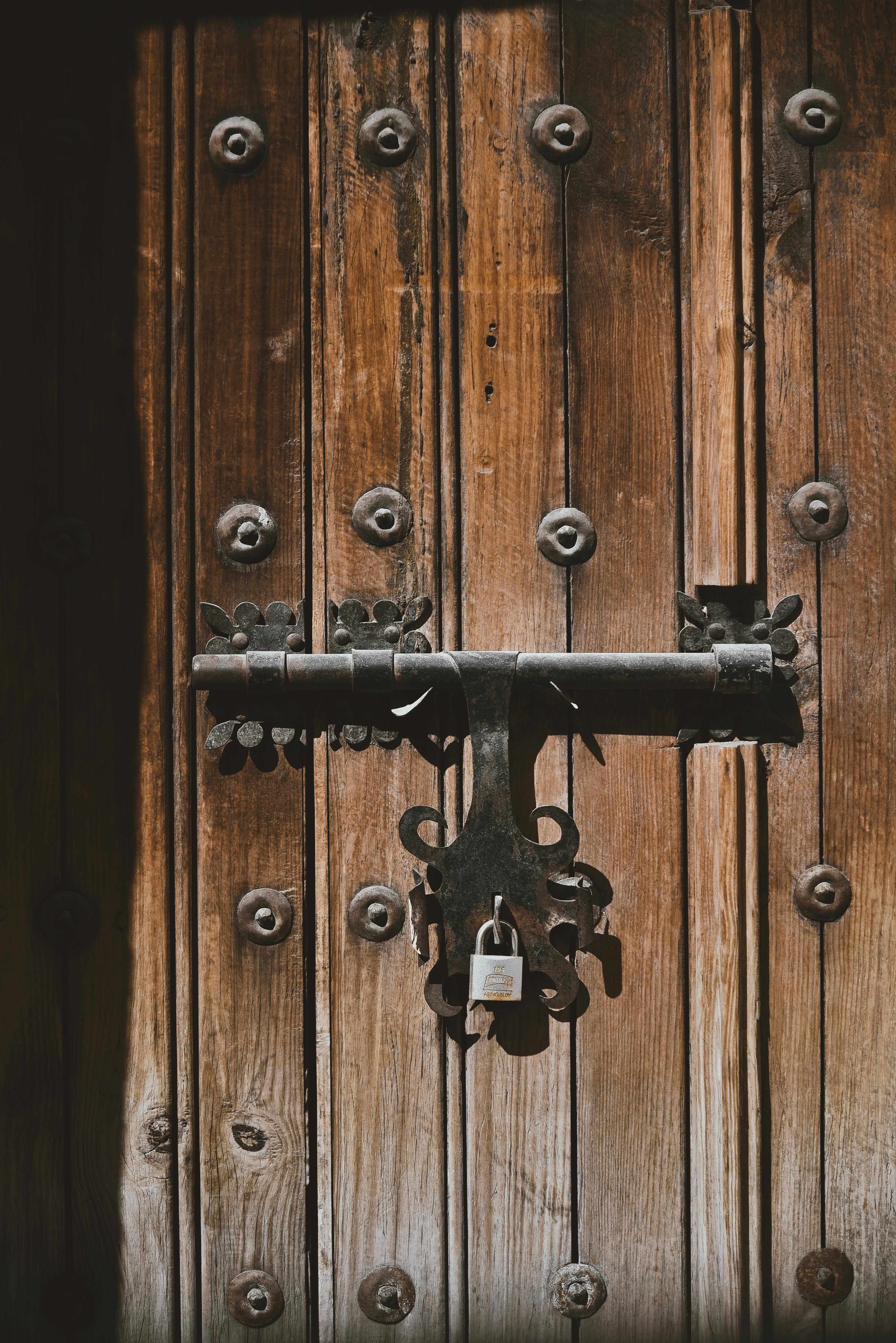 brown wooden door with padlock